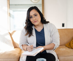 Picture of Jess Holding a Written Notebook while Looking at the Camera | Real Estate Burnout | The Listings Lab