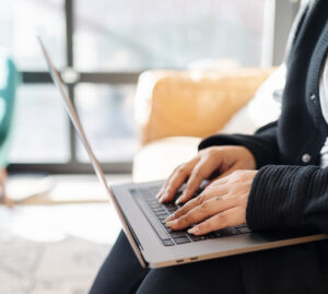 Picture of Jess Typing on her Laptop in her Lap | Facebook for Realtors | The Listings Lab