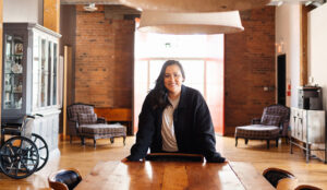 Picture of Jess Smiling on Camera Behind a Meeting Room Table | The Listings Lab
