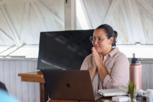 Picture of Jess Lenouvel from The Listings Lab Standing in Front of her Laptop Being Thankful while Listening to her Audience